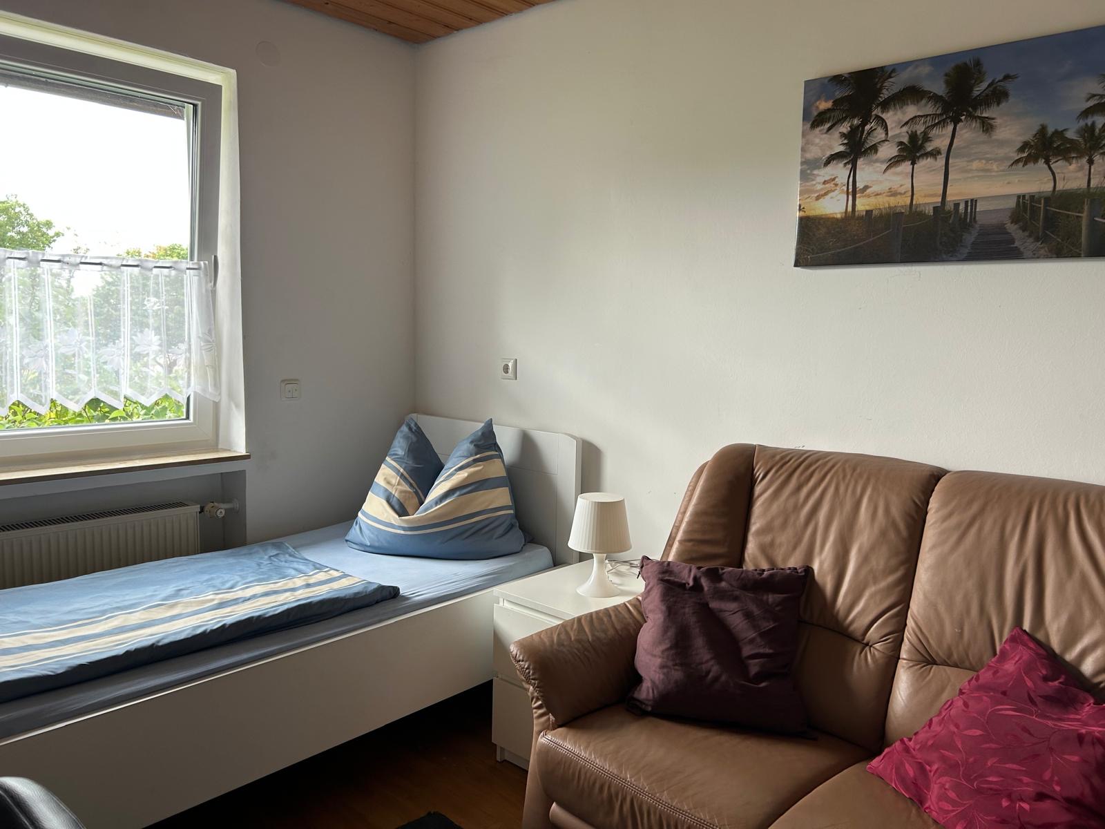 Zimmer mit Ledersofa und Bett – Monteurzimmer Donauwörth