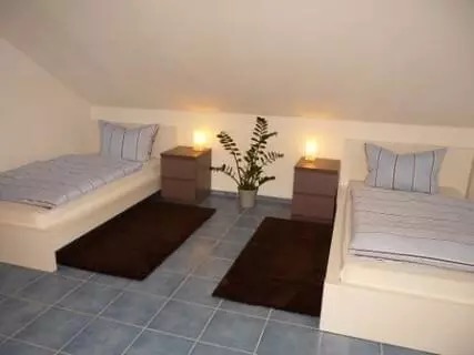 Zimmer mit Bett, Sessel und Couchtisch – Ferienwohnung Regina Donauwörth