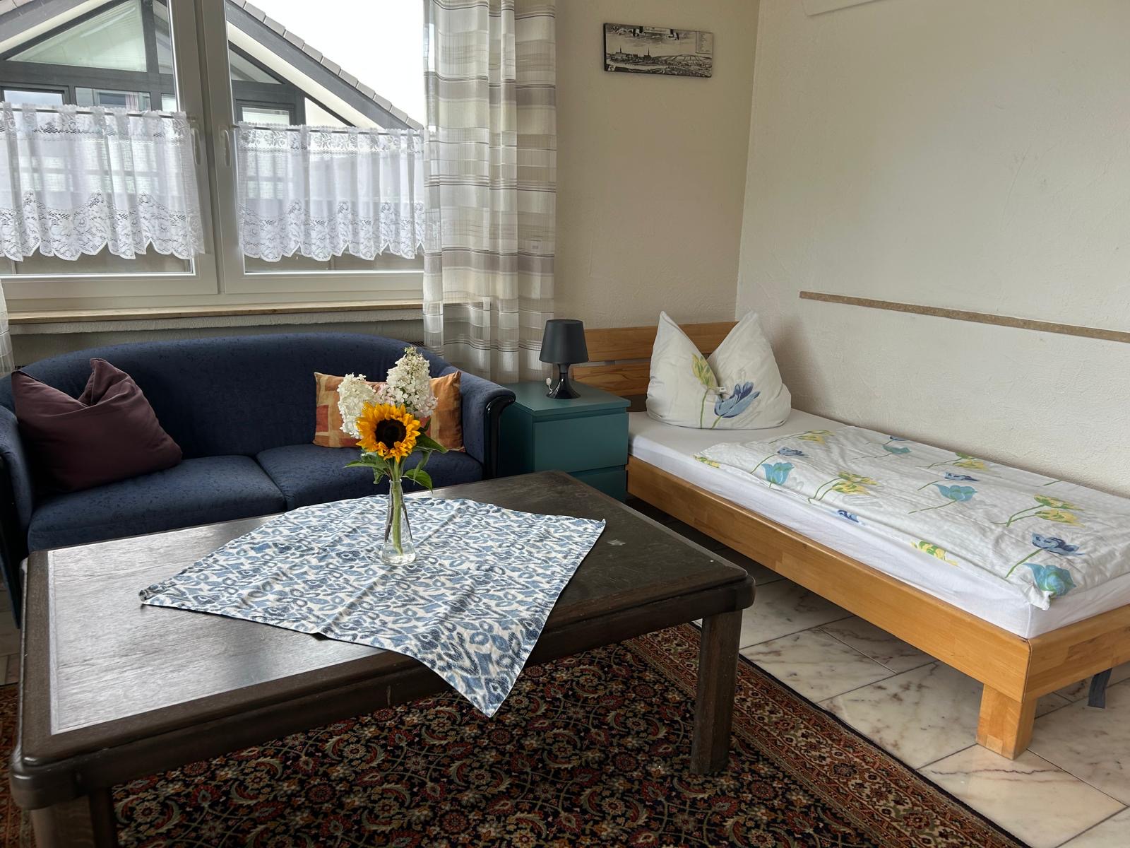 Sitzecke mit Sofa und gemütlichem Bett – Monteurzimmer Donauwörth